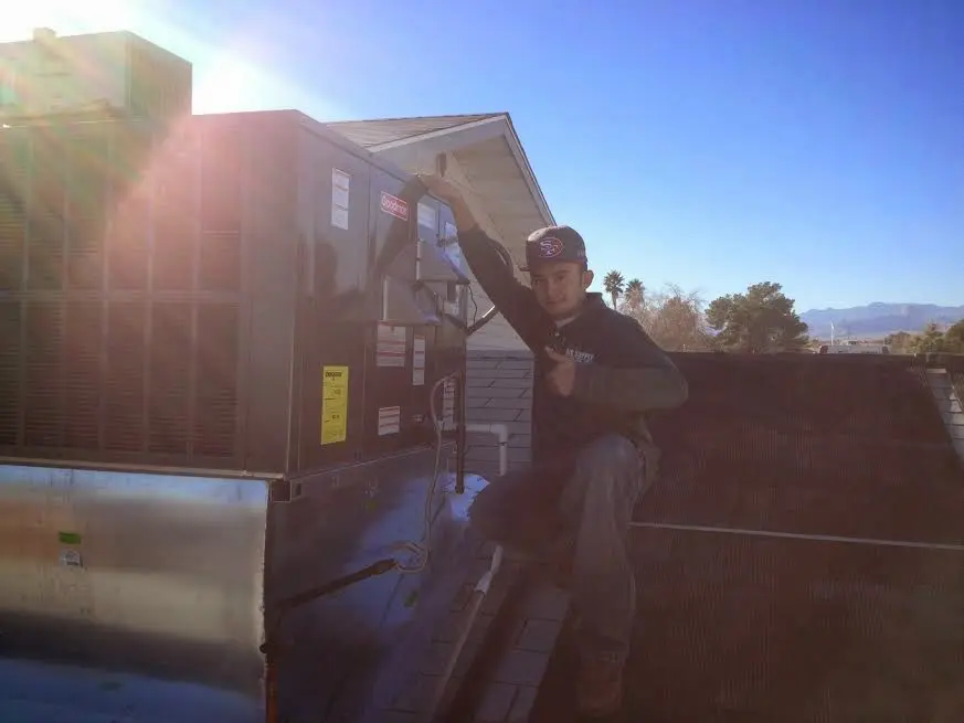 HVAC technician performing AC Tune-Up on a rooftop unit in Pocatello